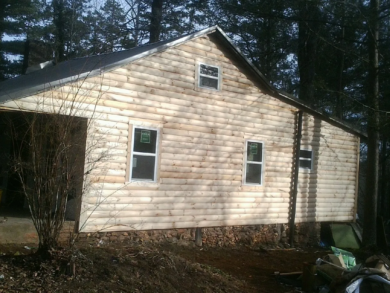 New log siding and dark metal roofing on a gable end in Buffalo